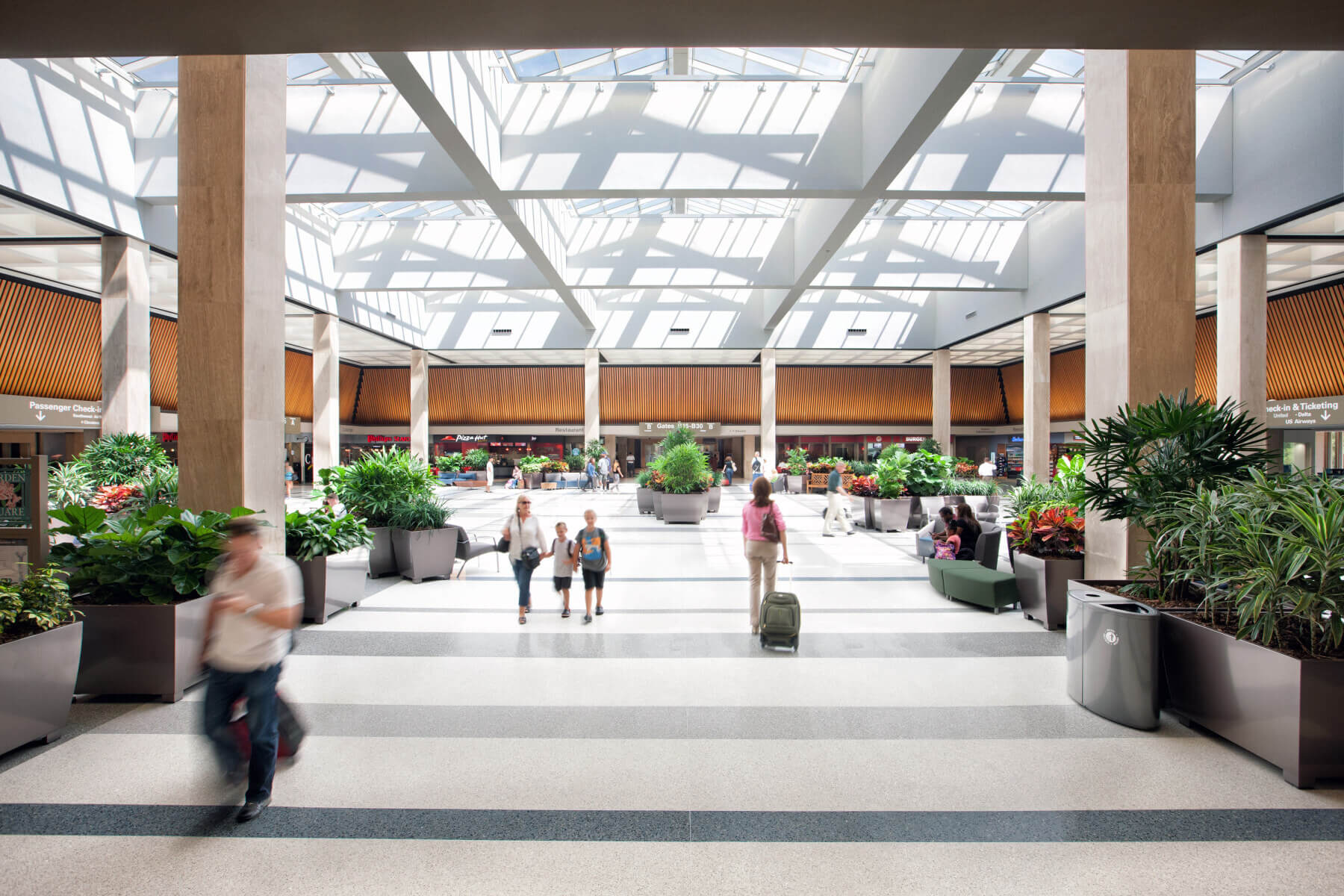 passengers waking through the terminal under a large skylight at Norfolk International Airport