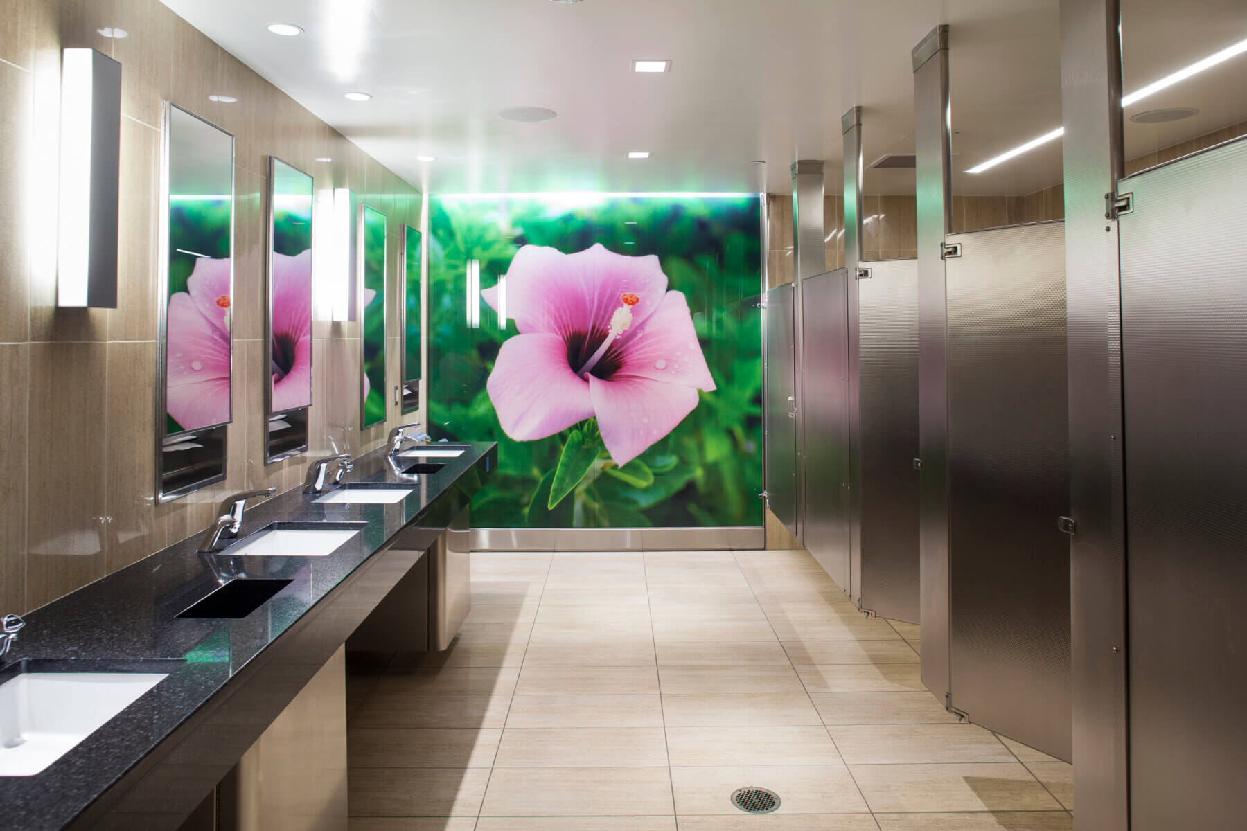 large scale wall graphic featuring a pink hibiscus in the bathroom at Tampa International Airport