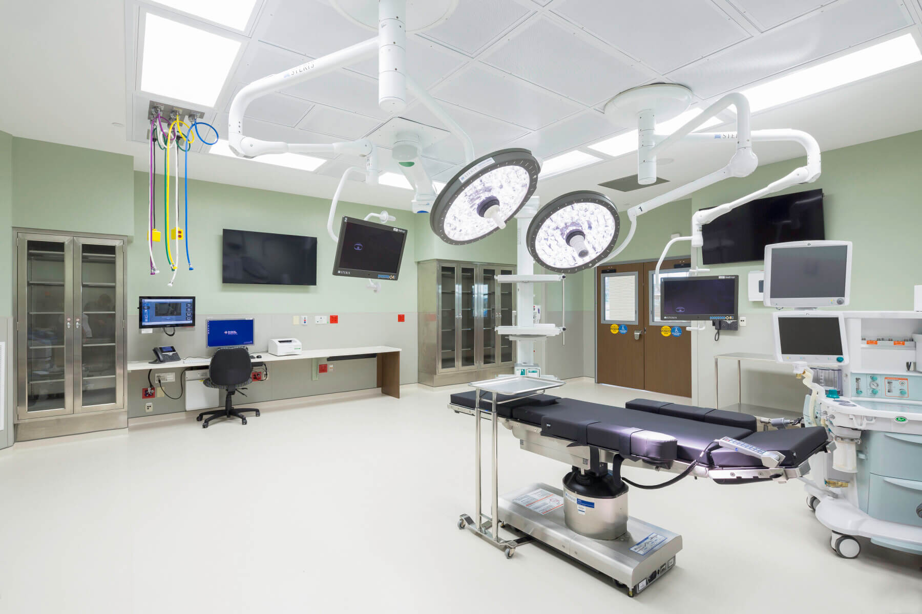 unoccupied procedural room with large medical device coming from the ceiling