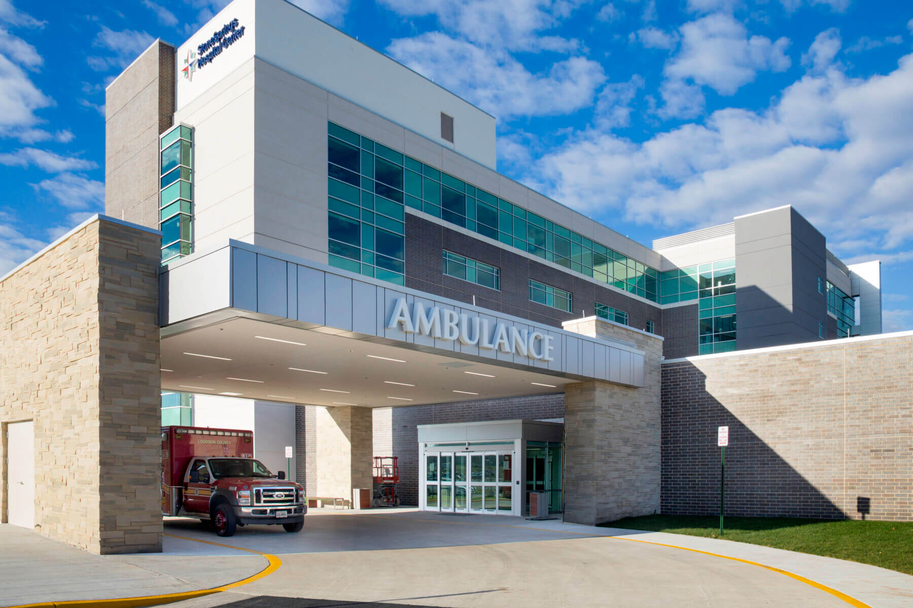 ambulatory entrance with a red ambulance parked near the facility doors