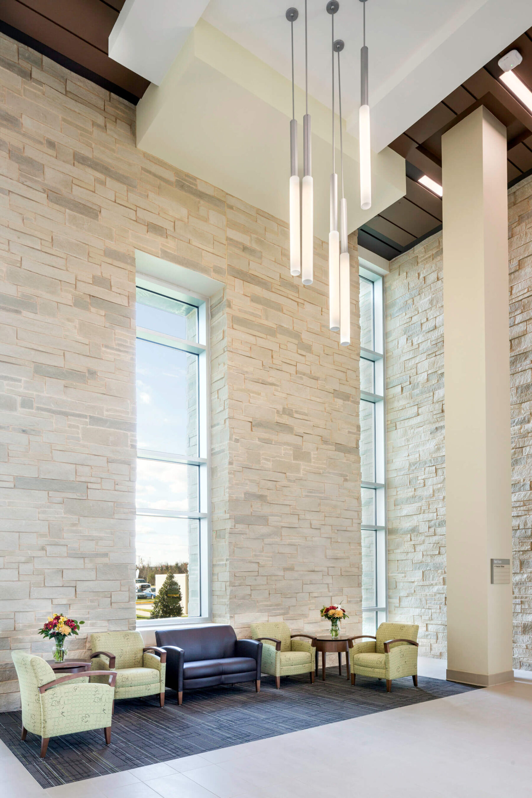 high ceiling with dramatic light fixture and stone walls in the lobby