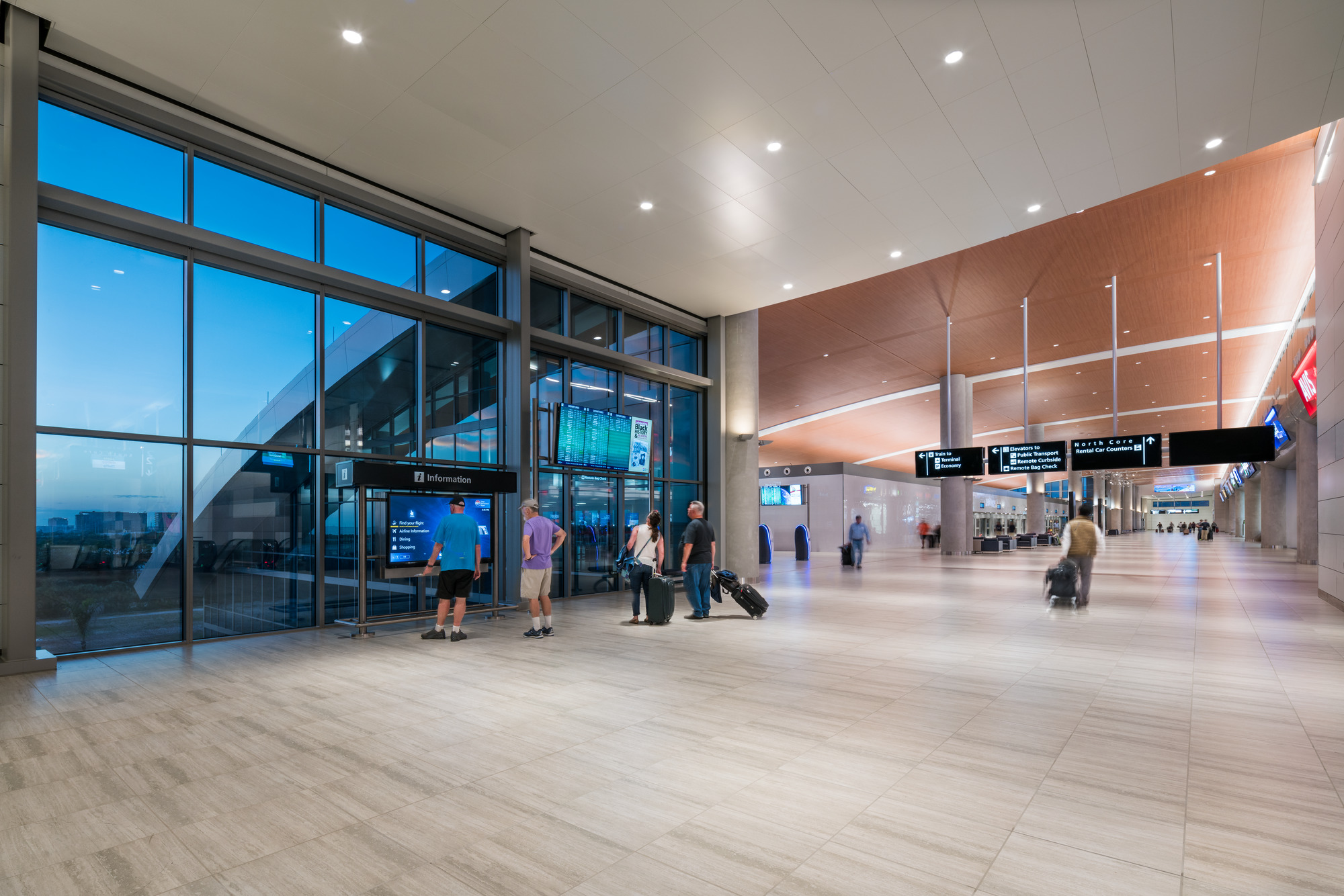 People using a wayfinding kiosk in the remote rental car center at tampa international airport