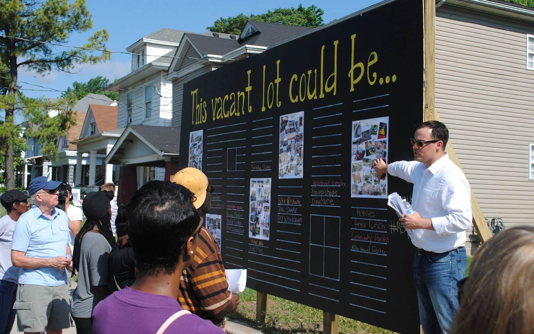 a man pointing to a sign for community engagement