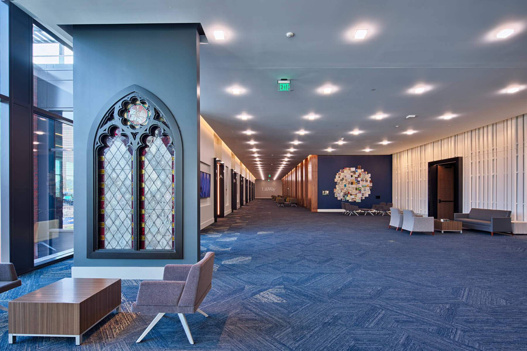 A hallway in the LifeWay Christian Resources building with chairs and a stained glass installation