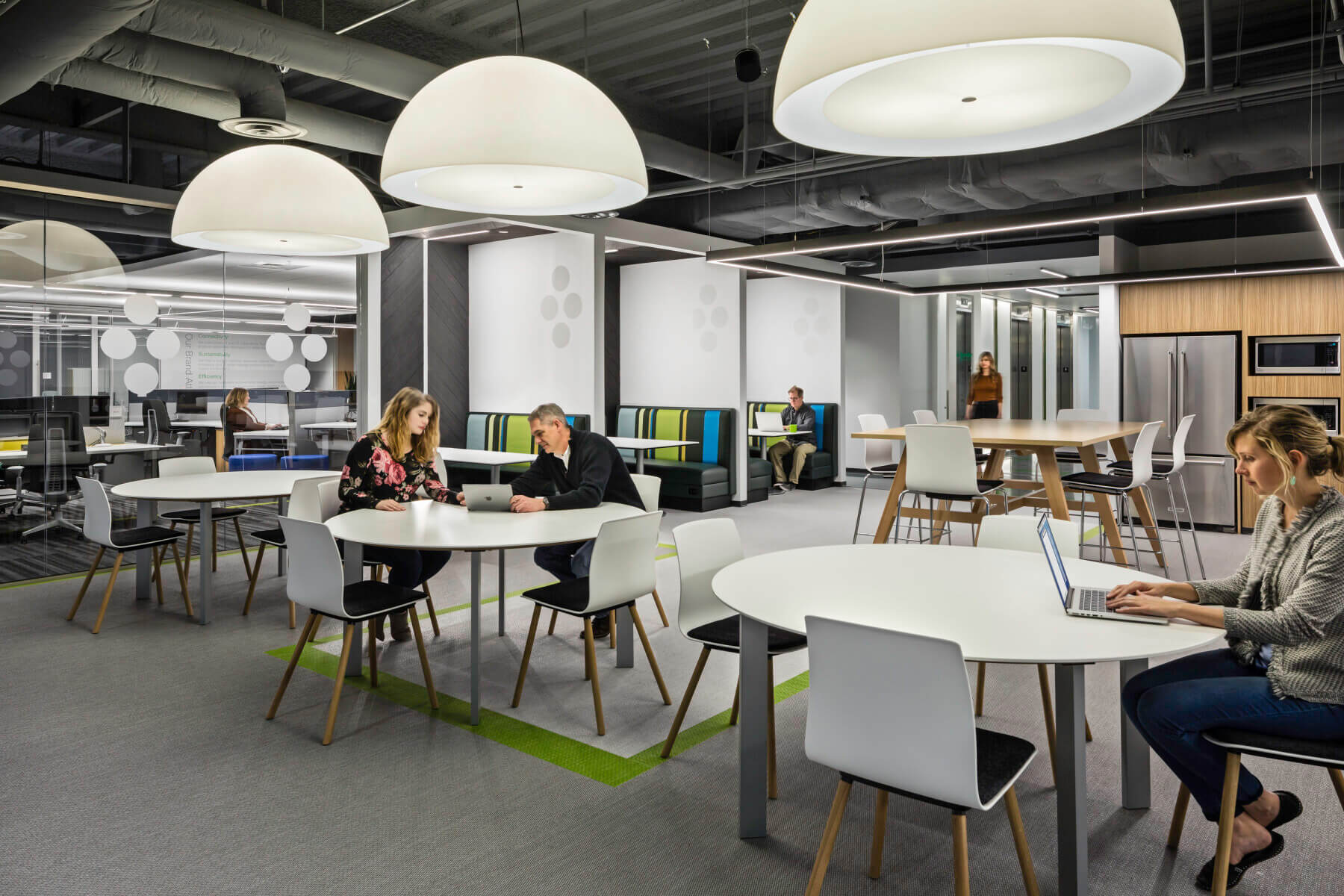 a hub with tables and a kitchen in the Schneider Electric Offices