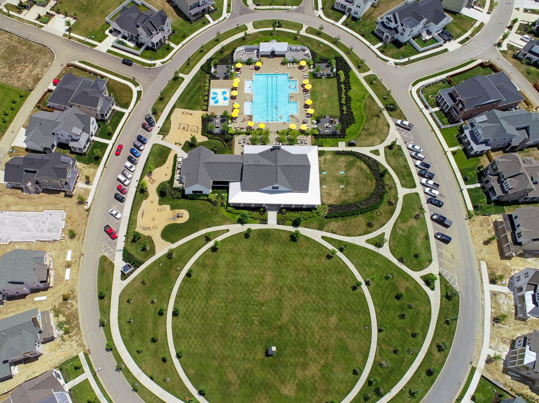 a drone shot showing a pool, field and houses in Durham Farms