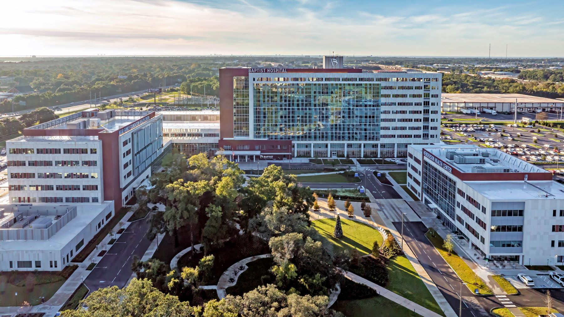 aerial view of a hospital campus with three buildings surrounding a park