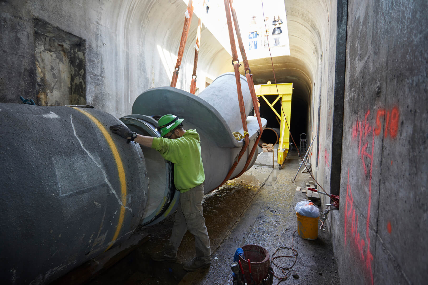 A worker steadies a pipe section along the route.