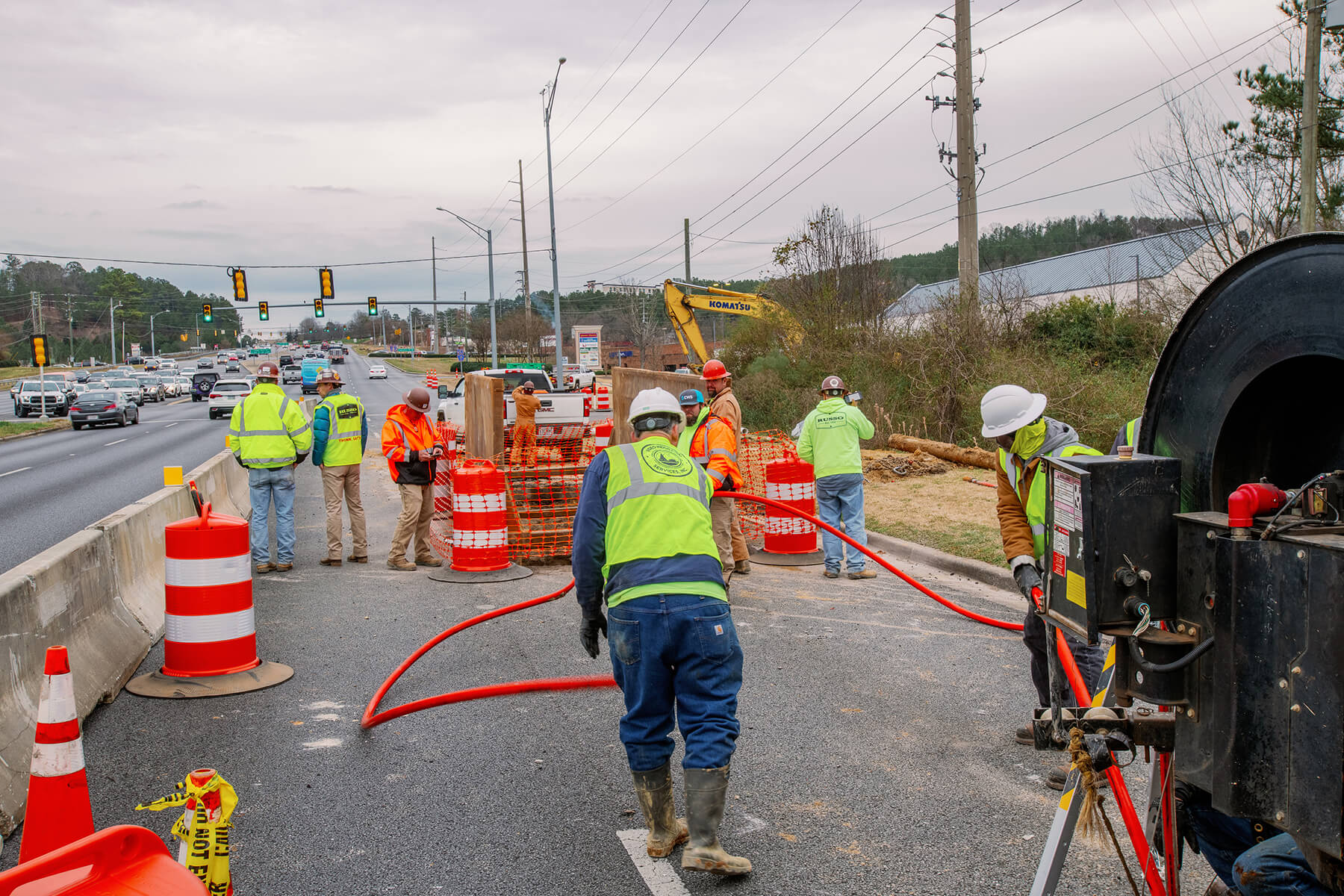 A group of workers in safety vests and helmets carry out repairs to Highway 280.