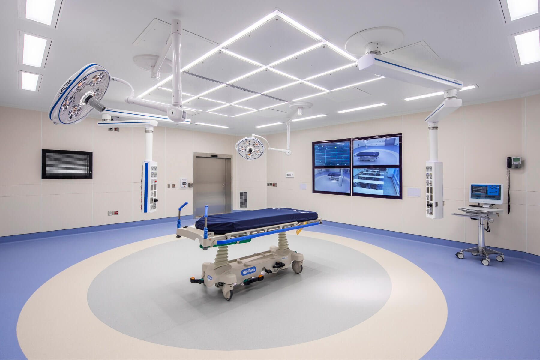 an operating room with tv screens on the wall