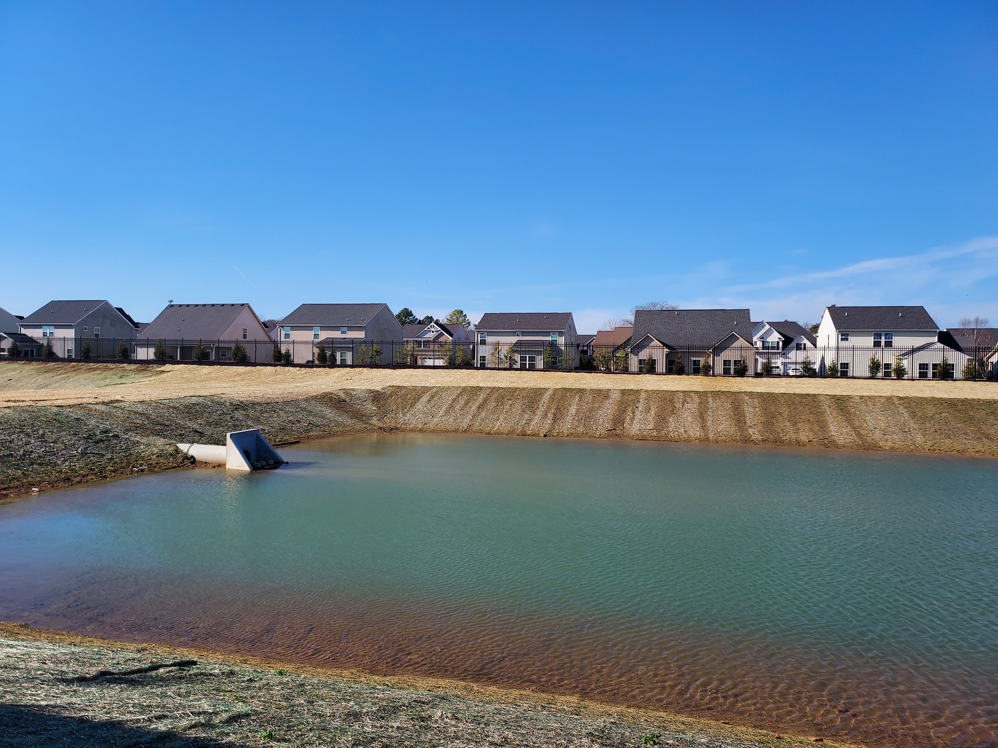 a pond at the project site that is lined with houses