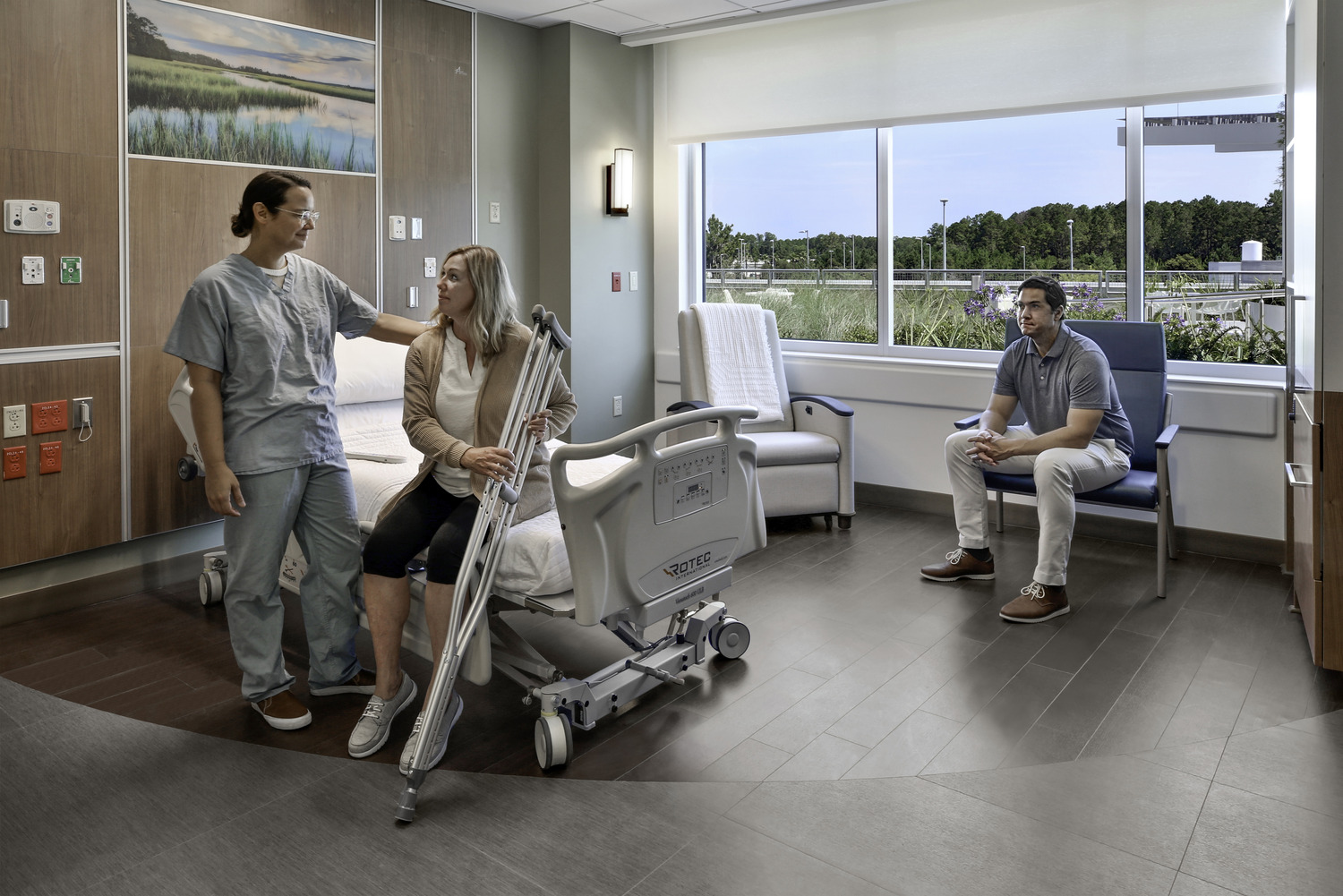 a nurse talking to a patient with crutches sitting on a hospital bed