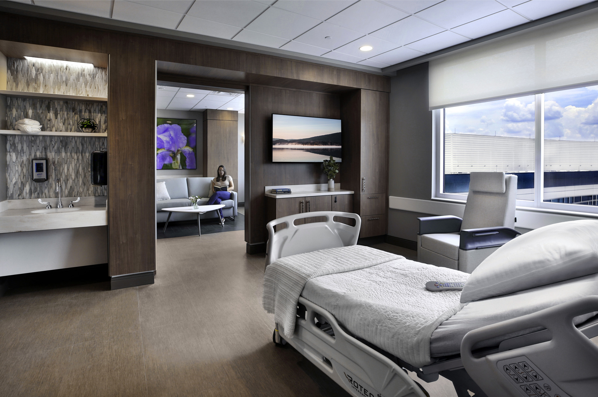 A person reading a book on a couch in a patient room