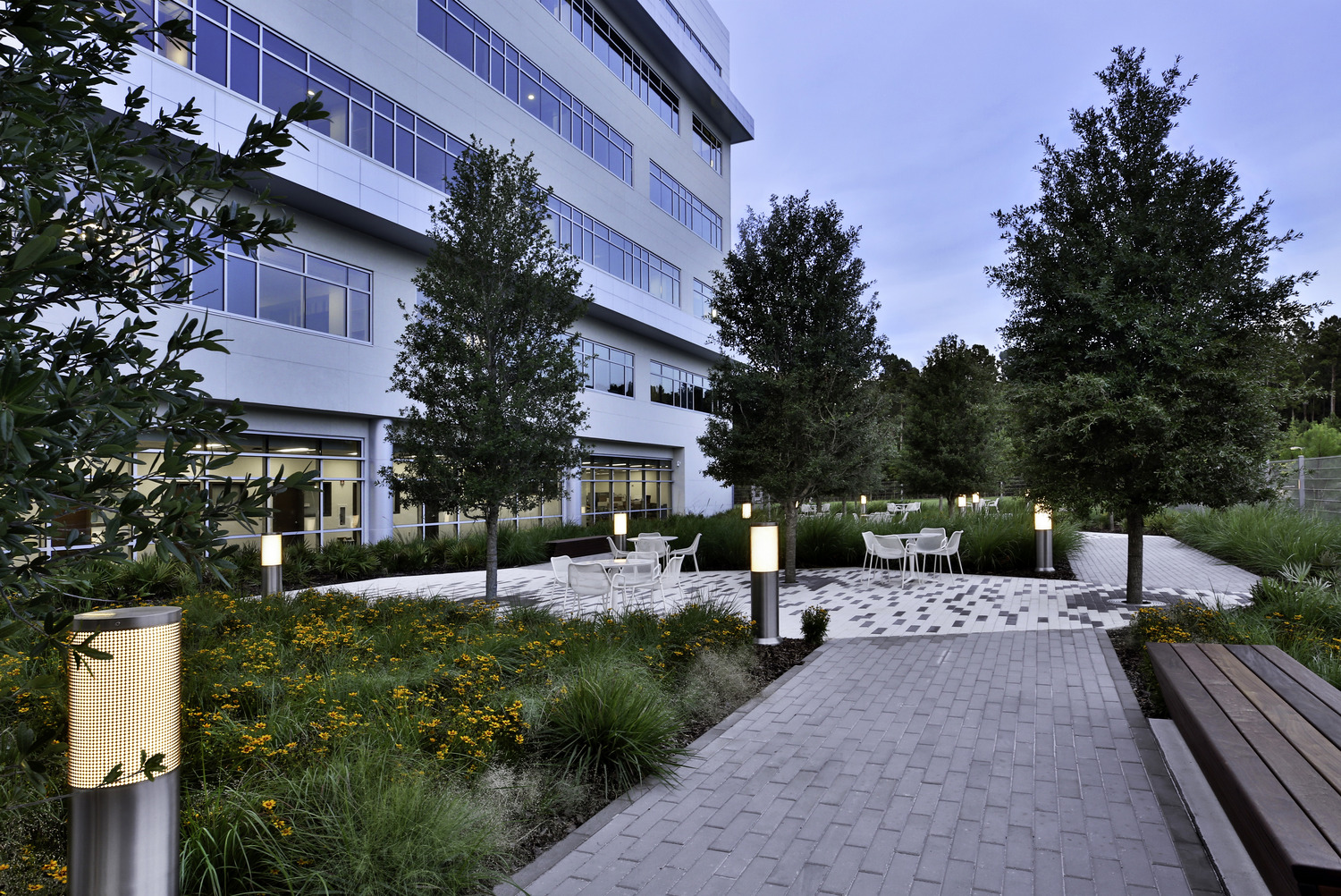 Patio with tables and chairs and plants outside a hospital