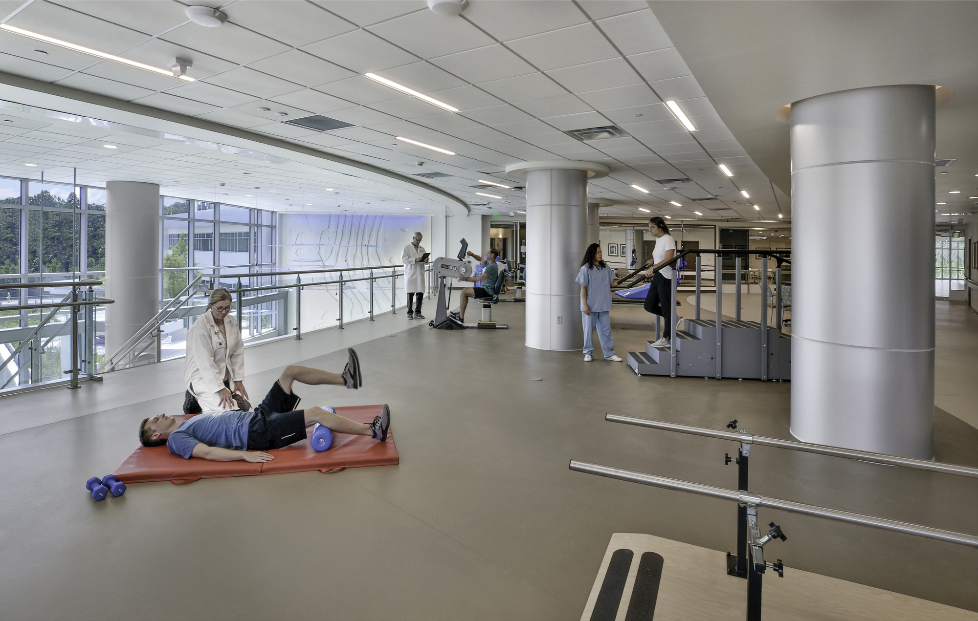 Patients doing physical therapy exercises in a rehabilitation gym