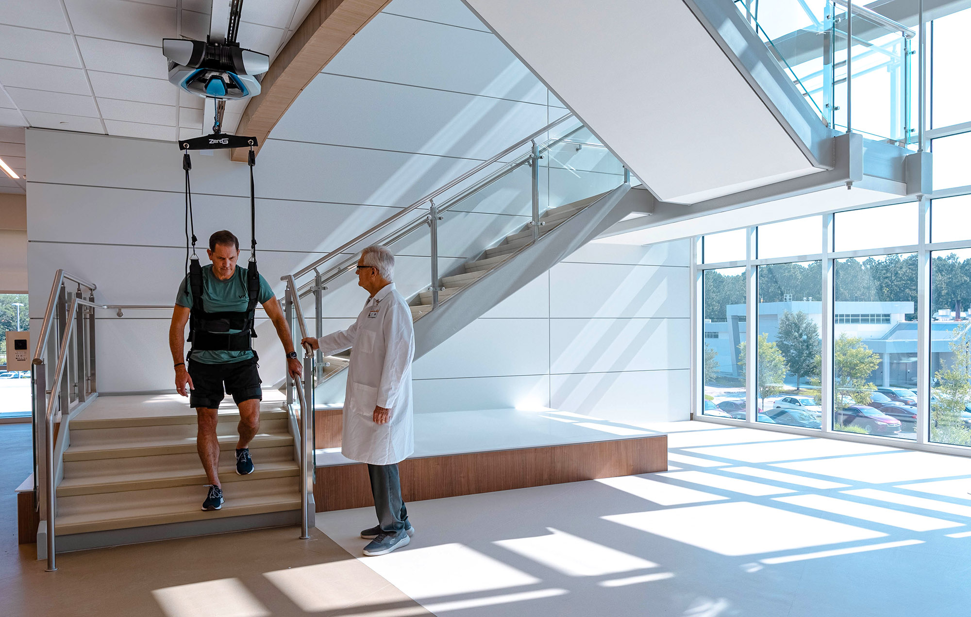 Doctoring helping a patient with gait training on stairs