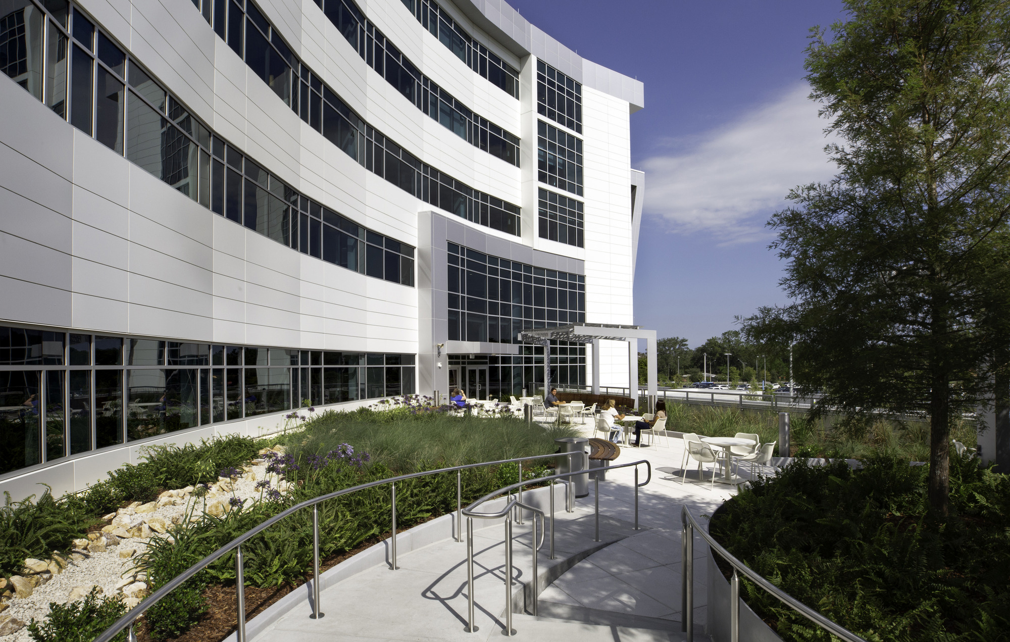 Outdoor terrace with ramp and seating outside a hospital