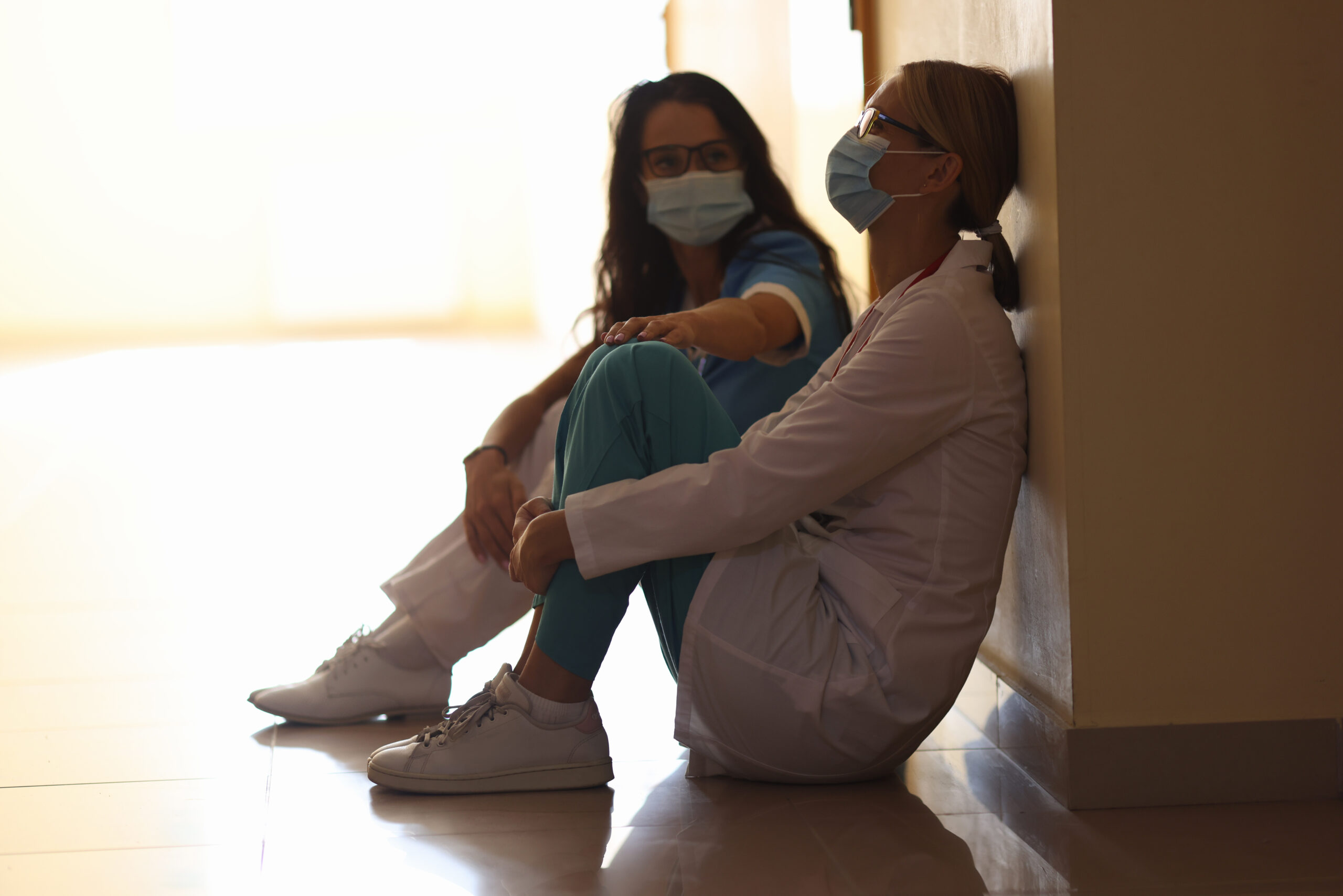 Two nurses sitting in a hallway