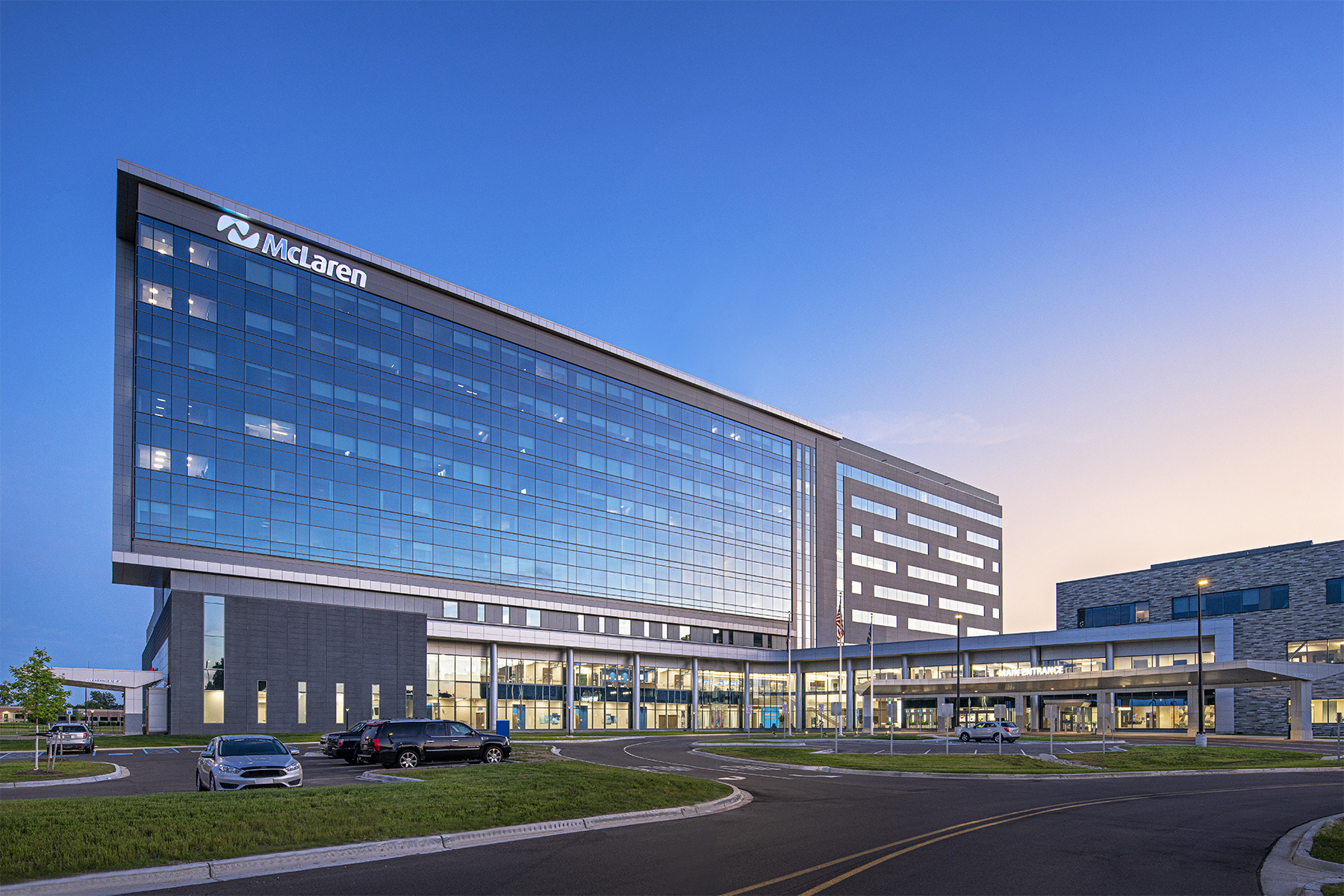 exterior of a nine-story hospital with a large glass façade at night