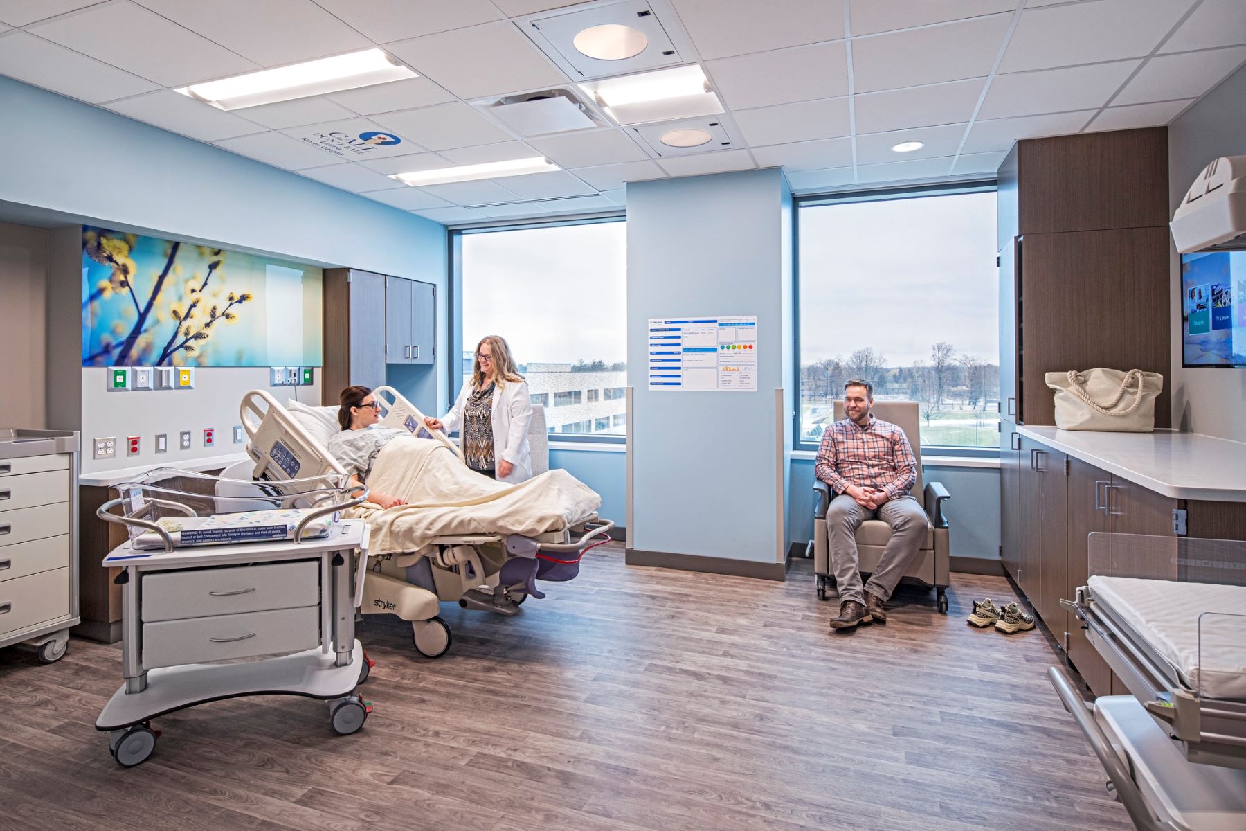 A doctor standing next to a pregnant woman in a hospital bed in a labor and delivery patient room