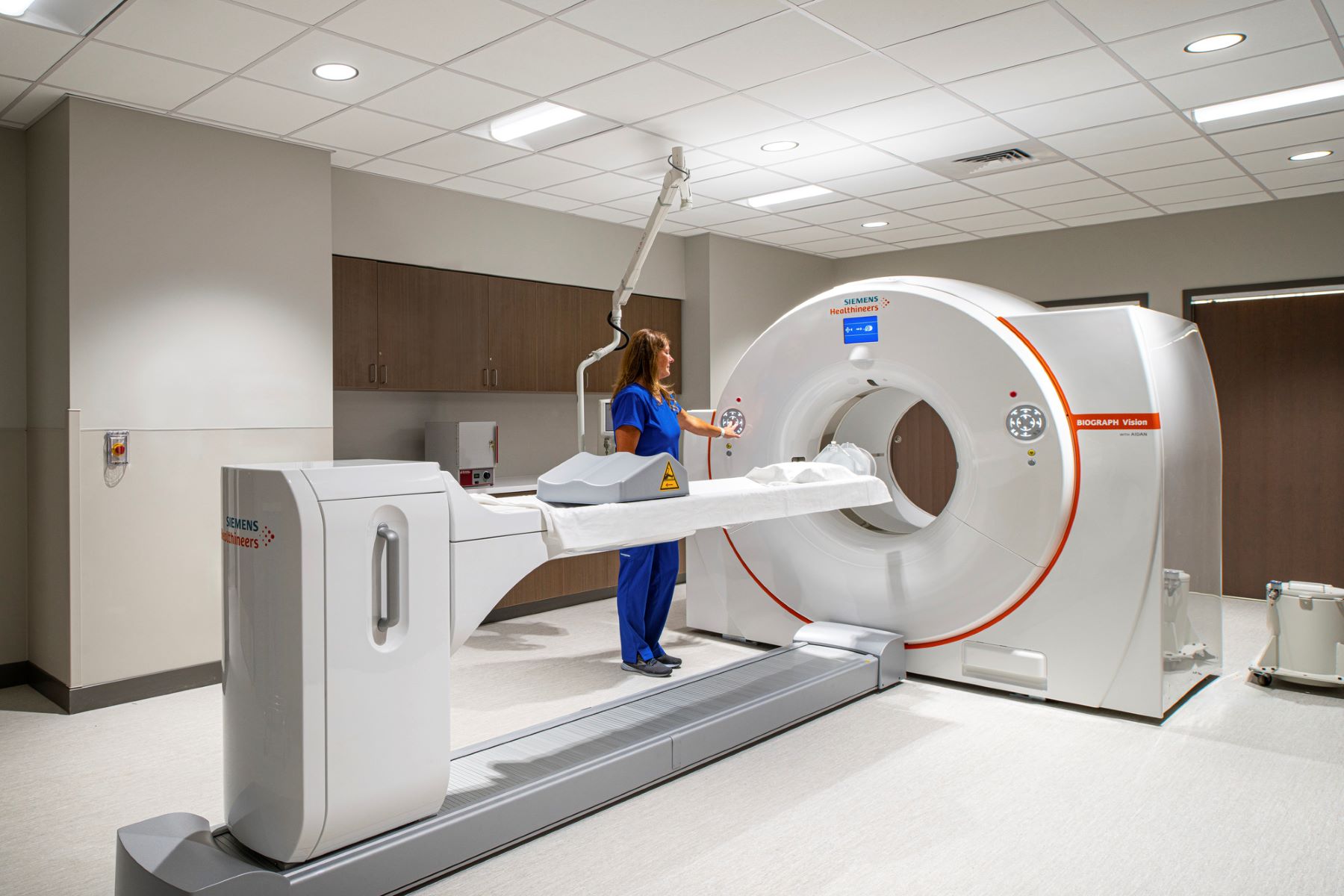 a nurse standing next to a CT scan machine