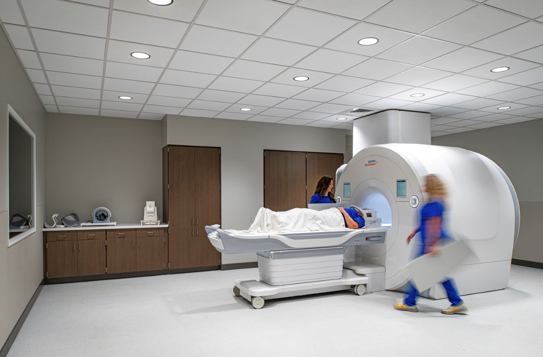 two nurses helping a patient undergoing a MRI scan