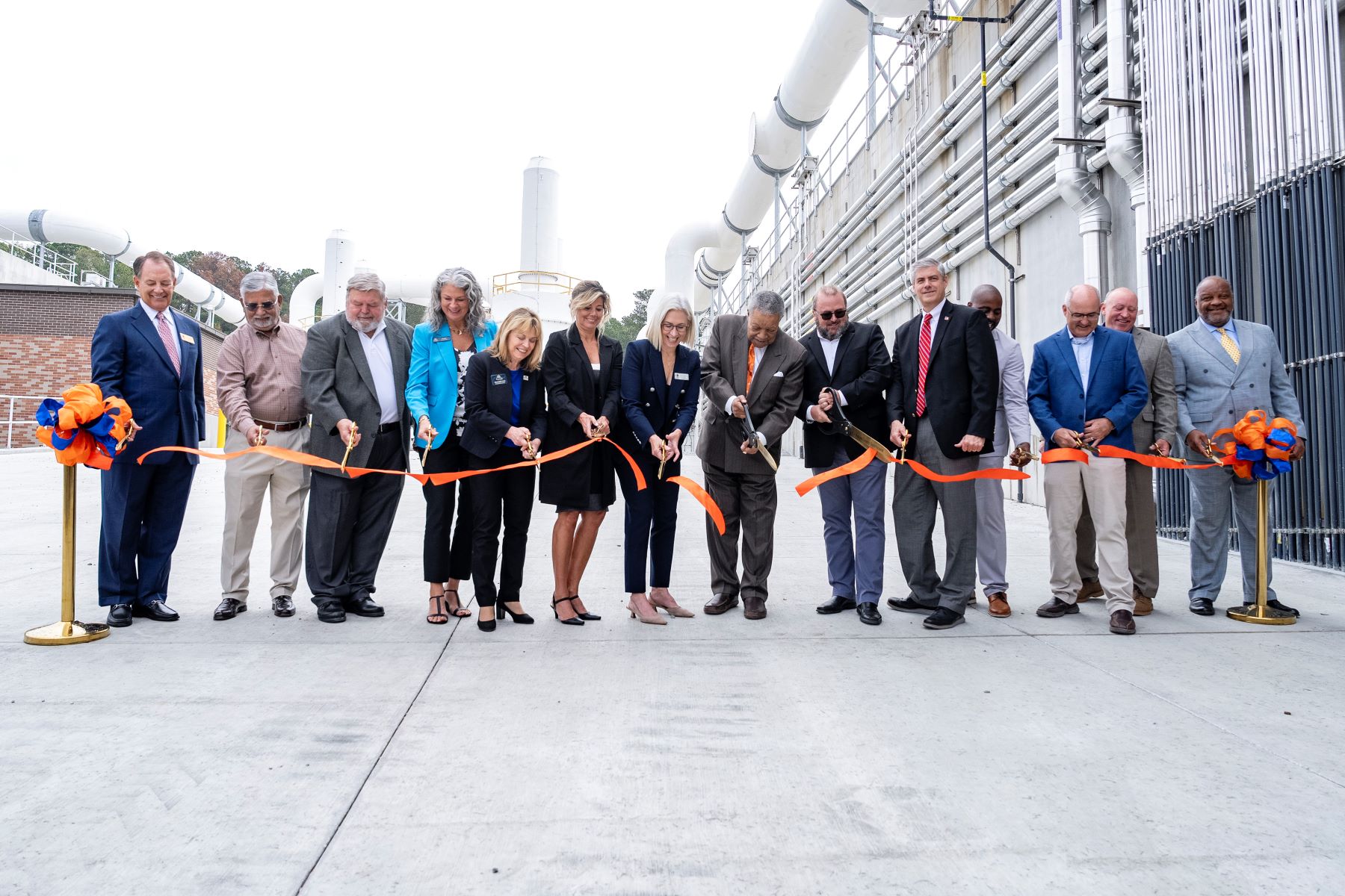 people cutting a ribbon at a wastewater treatment plant