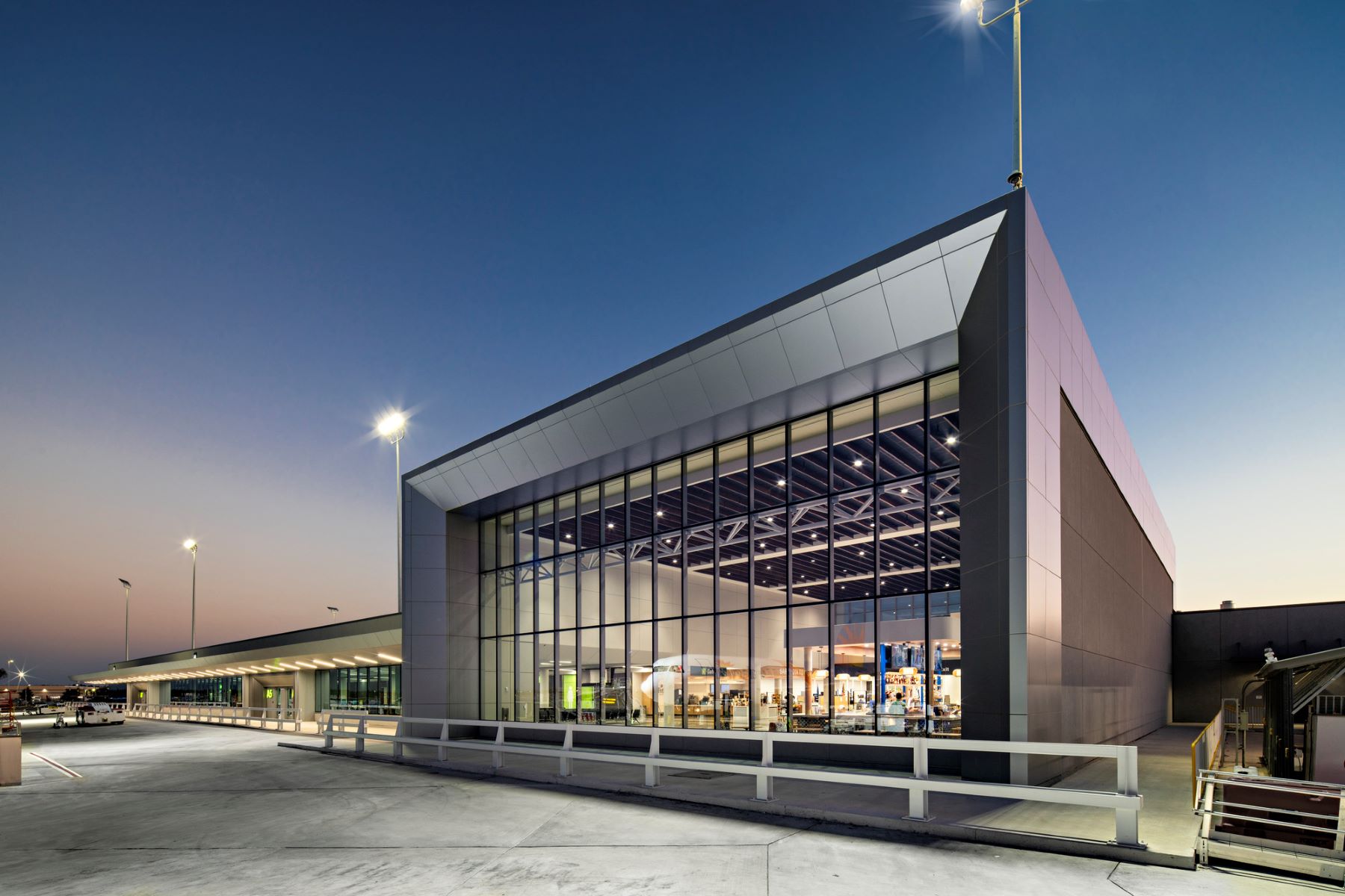 exterior of the new concourse at sarasota bradenton international airport featuring a large wall of windows at night